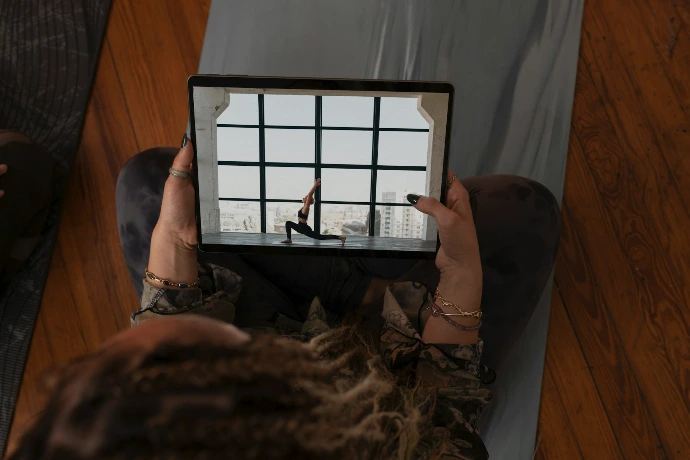 a woman holding up a tablet with a picture of a woman on it